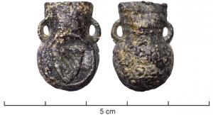 APL-9001 - Ampoule de pèlerinageplombAmpoule coulée en plomb, à panse circulaire et col trapézoïdal, deux petites anses en arcs de cercles à la base du col; une face est ornée d'un blason à bandes obliques, dans un cercle ; revers bombé avec un autre motif.