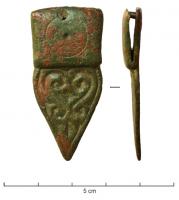 FRT-4046 - Ferret de ceinturebronzeFerret trapu, foliacé; décor excisé de type géométrique; large plaque de suspension coulée, ornée d'un simple cercle incisé, percée d'un rivet pour la fixation sur le cuir.