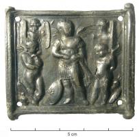 ACG-4009 - Plaque de cingulumalliage au plombApplique rectangulaire, sans charnière (simples tubes factices sur les côtés), percée aux angles de 4 trous pour rivets de fixation ; la face externe présentant un décor estampé, figurant trois Eros ailés dans un tableau militaire : au centre, un Eros-général cuirassé, avec un bouclier à ses pieds ; de part et d'autre, deux trophées d'armes au pied desquels se tiennent deux Eros debout, l'un pensif à gauche, l'autre les mains attachées dans le dos.