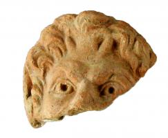 ANT-4017 - Antéfixe : tête de Satyreterre cuiteAntéfixe moulée, ornée en façade d'une tête de Satyre aux traits classiques, les cheveux traités en petites mèches, les oreilles étirées vers le haut, sans palmette autour.