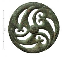 APH-4145 - Phalère de harnaisbronzeTPQ : 150 - TAQ : 250Applique circulaire, en relief plat et parfois percée de trois trous de fixation  sur le pourtour; le décor toujours ajouré est ici de type végétal, utilisant ici trois motifs de feuilles retournées et incurvées en spirale.