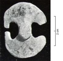 APH-4202 - Applique de harnaisbronzeTPQ : 1 - TAQ : 300Applique de harnais en forme de double pelte avec en son centre un bouton légèrement en relief ; au revers, un demi-anneau de fixation ou patte perforée.