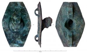 APH-4237 - Applique de harnaisbronzeTPQ : -30 - TAQ : 300Applique scutiforme, équipée au revers de deux bélières plates superposées ; sur la face externe, de semis de cercles oculés, d'où émerge en haut relief un buste d'homme penché vers l'avant, coulé avec l'objet.