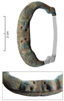 BAC-7058 - Boucle à chapebronzeTPQ : 1200 - TAQ : 1350Boucle à chape ; la boucle s'articule par une barre rectiligne étroite ; le jonc est légèrement renflé, orné de petits cercles estampés et sans doute doré ; le repos d'ardillon est épaulé de deux masques humains.