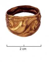BAG-3004 - Bague celtiqueor ou bronze plaquéAnneau plat et fermé, au chaton très élargi, tout le pourtour est orné de motifs au repoussé, esses ou visage humain.