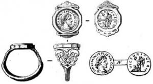 BAG-4050 - Bague monétaire à épaulementsorBague dont le chaton est constitué d'un aureus ; épaulements ornés (peltes) en opus interrasile ou avec un décor en relief.