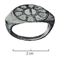 BAG-4242 - Bague émailléebronzeTPQ : 100 - TAQ : 275Bague à large chaton circulaire, entre deux ergots formant épaulements; le chaton comporte une couronne de loges radiales  émaillées autour d'un disque central lui-même divisé en deux loges, également émaillées.