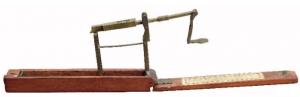 BLC-9002 - Balance monétairebronze, boisBalance monétaire pliante, dans son coffret de transport en bois. Une extrémité du fléau se rattache au fond de la boîte, l'angle formé par l'articulation se reportant sur une aiguille horizontale, dont la position sur une règle graduée indique la masse mesurée.