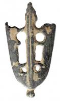 BOF-7008 - Bouterolle de fourreaubronzeTPQ : 1350 - TAQ : 1600Bouterolle à extrémité arrondie, simple gouttière avec deux ajours allongés encadrés par deux motifs circulaires ou en croissant; arête longitudinale, ergot central en facçade; bouton à la base.