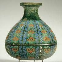 BTL-4003 - Bouteille émailléebronzeBouteille à corps piriforme, col étranglé, lèvre déversée à bord mouluré; le vase a été coulé à la cire perdue, en deux parties assemblées ensuite par brasure. La surface est entièrement couverte de motifs émaillés, alignés en bandes verticales.