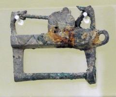 CDN-6003 - CadenasbronzeCadenas constitué d'un boîtier oblong, de section variable (circulaire, tréflée, cruciforme…) orné d'un décor géométrique sur les côtés ; ouverture à trois fenêtres sur un petit côté ; une tige appointée est parallèle au bloc-serrure. Le verrouillage s'effectue par la fixation, au moyen d'un ressort placé dans le boîtier, d'une pièce latérale qui vient coiffer la pointe en s'engageant dans le côté ouvert du boîtier.