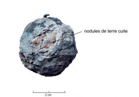 CUB-9001 - Curseur de balance : terre cuite et plombplombIl s’agit d’un ensemble de nodules en terre cuite rouge, assemblés dans une enveloppe de plomb. Le tout devait être ceinturé d’une bande en alliage cuivreux et une bélière, assez légère, permettait de suspendre le poids.