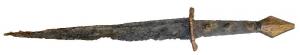 DAG-7005 - Dague à pommeau losangiquefer, bronzeDague à lame triangulaire effilée, le dos rectiligne souligné d'une profonde cannelure sur chaque pace; garde en alliage cuivreux, ajourée d'une ouverture reproduisant la section de la lame, avec des crans sur les côtés; pommeau losangique, également rapporté et en alliage cuivreux, orné d'inscisions souvent pseudo-héraldiques sur une face.