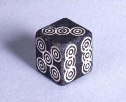DEJ-4011 - Dé cubique pleinpierreDé taillé et poli dans une roche dure, ou plus rarement tendre ; le marquage, de 1 à 6, fait généralement appel à des cercles pointés ou oculés.