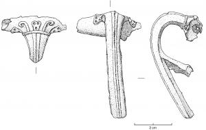 FIB-4054 - Fibule à arc non interrompubronzeTPQ : 10 - TAQ : 70Arc tendu, coudé et épaissi à la tête, à bords parallèles, orné d'une côte centrale et de deux latérales (décor parfois absent) ; ressort protégé ; porte-ardilon trapézoïdal, ajouré ou fenestré. A la tête, décor caractéristique (fleuron ?) encadré de deux crosses en relief.