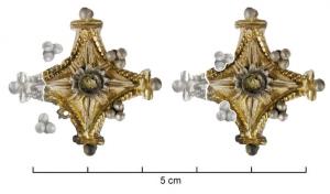 FIB-4224 - Fibule losangiqueargentTPQ : 1 - TAQ : 150Broche dont l'arc a la forme d'un losange aux côtés concaves, les pointes terminées par des fleurons marqués d'un bouton riveté; au centre, bouton également riveté dont partait une collerette ajourée, reposant près des bords guillochés; détails dorés.
