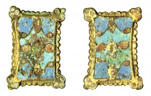 FIB-6001 - Fibule rectangulaire émailléebronzeTPQ : 800 - TAQ : 950Fibule rectangulaire à bords concaves, souvent à bordure bouletée. Décor (émail le plus souvent cloisonné) de dessin variable, souvent centré.