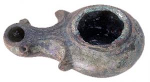 LMP-4028 - LampebronzeTPQ : 1 - TAQ : 150Lampe à bec allongé et volutes, avec deux petits fleurons de chaque côté du bec; trou de remplissage central, sans anse.