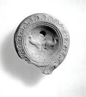 LMP-41142 - Lampe Loeschcke IV : Dauphins terre cuiteTPQ : 50 - TAQ : 100Lampe ronde à bec en ogive à volutes. Médaillon orné de deux dauphins antithétiques.