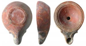 LMP-41528 - Lampe à bec à doubles volutesterre cuiteLampe moulée, sans anse. Réservoir circulaire de profil convexe. Bandeau étroit à deux sillons concentriques, penché vers l'intérieur. Disque en cuvette profonde limitée par deux sillons.  Bec long  étroit, arrondi, flanqué de deux volutes doubles se poursuivant sous le bec. Base plate limitée par un anneau plat en relief. Engobe rouge vif.