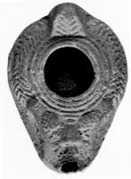 LMP-4152 - Lampe syro-palestinienne (type tardif)terre cuiteTPQ : 200 - TAQ : 350Lampe de forme ovoidale avec large bec. Epaule  richement décorée de feuilles de palme et de grappes de raisin. Anse conique.