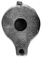 LMP-4189 - Lampe syro-palestinienne tardive avec réflecteurterre cuiteTPQ : 400 - TAQ : 600Lampe de type syro-palestinien avec large réflecteur (perdu). Epaule décorée de motifs circulaires garni. Bec carré surmonté par un rectangle décoré d'une ménorah.