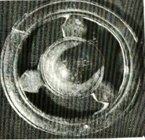 PHH-4004 - Phalère de harnaisbronzeTPQ : 1 - TAQ : 300Phalère dont l'ombilique hémisphérique central est relié au cadre par trois éléments circulaires.