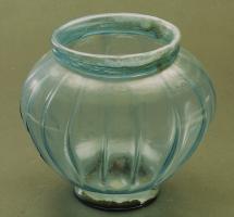 POT-4002 - Urne Isings 67c1verreUrne soufflée, avec un fond légèrement dégagé et un col ourlé formant un bandeau vertical; la panse renflée est ornée de côtes verticales ou obliques, en léger relief. Fond annulaire soufflé, repoussé vers l'intérieur.