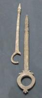 QNL-4013 - Quenouille : pomme de pin ou balustreosTige rectiligne, terminée d'un côté par un anneau de la taille d'un doigt, de l'autre par un bouton effilé (balustre), parfois marqué d'incisions croisées (pomme de pin).