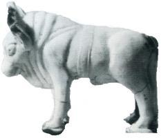 STE-4104 - Statuette zoomorphe : bovidéterre cuiteTPQ : 1 - TAQ : 300Taureau debout, les poils de la tête ne sont pas indiqués. Corps massif avec les plis de peau au garrot. Les épaules sont entourées d'une sangle transversale avec une large bande autour du corps, indiquant un animal de trait.