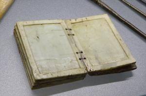 TBT-4003 - Tablette (tabella cerata)ivoirePage de tablette rectangulaire, avec une feuillure et une zone centrale en dépression, des deux côtés (sauf pour les pages terminales du codex); d'un côté, perforations souvent regroupées deux à deux, pour l'articulation.