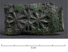 BAC-7056 - Boucle à chapebronzeBoucle à barre épaisse, rectiligne ; chape rectangulaire, étroite et allongée, ornée de motifs estampés simples : fleurs... ; 4 rivets de fixation dans les angles.