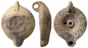 LMP-41614 - lampe à bec cordiforme et ombilic centralterre cuiteTPQ : 175 - TAQ : 225Lampe moulée, anse verticale percée à deux sillons sur la tranche. Réservoir circulaire à profil biconvexe. Bandeau penché vers l'extérieur orné d'une couronne de laurier. Disque en simple cuvette limitée par deux sillons et un anneau de stries rayonnantes.  Ombilic central strié et percé. Bec arrondi cordiforme. Base circulaire plate en léger relief limitée par un  anneau plat et deux sillons concentriques. .  Restes d'engobe gris foncé sur toute la lampe.