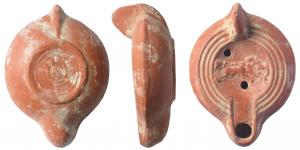 LMP-41654 - Lampe africaine à canal ouvertterre cuiteTPQ : 250 - TAQ : 350Lampe moulée, anse verticale pleine. Réservoir circulaire de profil biconvexe. Trois profonds sillons sur le bandeau. Grand disque et petit bec entourés par un bourrelet. Quadrige à gauche sur le disque. Base plate limitée par un bourrelet ; contient une série de sillons concentriques et des signes graphiques illisibles .Engobe rouge orangé.