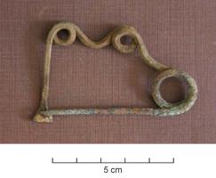 FIB-2633 - Fibule serpentiforme corsebronzeFibule à ressort unilatéral, large spire ; l'arc est constitué d'un segment rectiligne et serpentant, constitué d'une seule ondulation entre deux boucles. Le pied, en tige rectiligne en angle droit avec l'arc, se termine par un porte-ardillon en étrier, formé d'un simple écrasement.