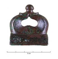AJG-3004 - Anneau de joug de type AvenchesbronzeTPQ : -100 - TAQ : 1Anneau de joug en fonte creuse, à décor plastique, comportant un anneau ovale ou réniforme posé sur une base et surmonté d'un bouton central strié pour recevoir une couche d'émail.