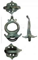 AJG-4033 - Anneau de jougbronzeTPQ : 50 - TAQ : 200Anneau de joug monté sur une plaque accostée de deux ergots redressés et bouletés ; la plaque peut être ornée de festons et éventuellement ajourée ; robuste boucle de fixation par-dessous ; au sommet de l'anneau, ornement triangulaire ajouré (en forme d'applique de joug ?).