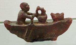 AML-4041 - Amulette ou crepundium : rameurambreTPQ : 50 - TAQ : 200Amulette ou crepundium en ambre, figurant un rameur transportant un vase et une outre (?).