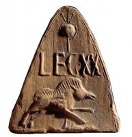 ANT-4013 - Antéfixe : Sanglier LEG XXterre cuiteAntéfixe à simple façade triangulaire, marquée d'un sanglier courant à gauche, surmonté de l'inscription LEGXX et d'un motif variable au-dessus (trophée : bouclier circulaire et 3 lances sur une hampe).