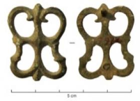APH-4151 - Applique de harnaisbronzeApplique de harnais ajourée, composée de branchages plastiques formant une pelte, et deux crosses rejoignant les bords par dessous; au revers, deux fixations.