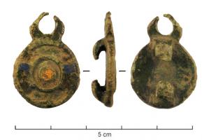 APH-4187 - Applique de harnais émailléebronzeApplique de harnais, comportant un disque creusé de trois zones concentriques émaillées avec des inclusions de verre; sur le côté, anneau ou lunule; au revers, deux pattes de fixation repliées vers le centre de l'objet.