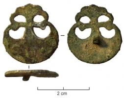 APH-4242 - Applique de harnais : peltebronzeApplique plate, découpée en forme de pelte et parfois au centre un cercle gravé pouvant porter la trace d'un décor rapporté par brasure; pointe de fixation centrée au revers.