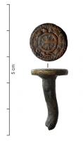 APH-6001 - Rivet monétiformebronze doréTPQ : 1150 - TAQ : 1250Ornement (fixé à l'arrière à l'aide d'une longue tige de section ronde), présentant au sommet , en léger relief et doré, un motif armorié d'inspiration monétaire (types du Sud de la France).