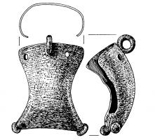 APJ-4012 - Applique de jougbronzeApplique formant une sorte de coque quadrangulaire, aux côtés concaves, ouverte au sommet (deux trous de fixation), pourvue de ce côté d'un robuste anneau perpendiculaire à la face externe, de l'autre de deux boules d'angles, permettant peut-être un accrochage avec des liens ; revers creux.