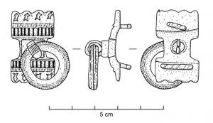 APT-4022 - Applique à tenons en T, type B2bronzeApplique pourvue au revers de 2 tenons en T, normalement guillochés sur la partie extérieure de la barrette ; l'objet est percé transversalement et un anneau retenu par un crampon replié à l'arrière y joue librement. Ce type présente une forme symétrique autour de l'anneau central, avec des extrémités formées de deux appendices rectangulaires, ornés de traits parallèles niellés et de petites loges d'émail crénelées, ou creusés de loges émaillées plus étendues.