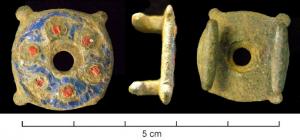 APT-4034 - Applique à tenons en T, type A2abronzeApplique circulaire émaillée, comportant un vide central et quatre petits ergots sur le pourtour. Le champ creusé pour recevoir un décor émaillé comporte quatre ou six disques champlevés, également émaillés.