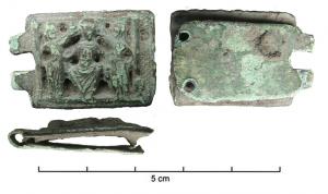BAC-6049 - Boucle à chape : le Christ sur un trône, accompagné de saintsbronze doréTPQ : 1150 - TAQ : 1250Boucle ovale, chape rectangulaire; le décor en relief plat figure le Christ en majesté, assis sur un trône, flanqué de deux personnages qui lèvent un bras vers la tête du personnage central, en portant parfois un globe. Objets dorés.