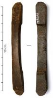 BAF-4001 - Barrette de suspension de fourreau de spathaos ou bois de cerfPlaque allongée, aux côtés légèrement arqués et soulignés de filets, ménageant sur sa face inférieure un vide destiné à une sangle plate; les deux extrémités sont amincies afin de permettre la ligature de la barrette sur le fourreau. Objet lisse ou orné de cannelures longitudinales