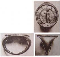 BAG-4064 - Bague à médaillon monétiformeorTPQ : 1 - TAQ : 250Bague dont le jonc s'élargit pour accueillir un grand chaton circulaire, un médaillon serti pourvu d'un motif et de légendes dans le style monétaire. Il s'agit d'anneaux personnels d'officiers de l'armée.