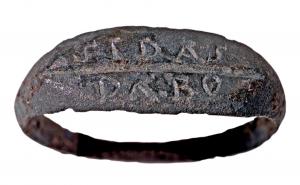 BAG-4077 - Bague à chaton gravé sur deux lignesbronzeTPQ : 1 - TAQ : 200Bague à jonc plat, chaton légèrement élargi et aplati, avec une inscription non rétrograde répartie sur deux lignes séparées par un trait horizontal.